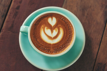 Latte art coffee cup with milk on wooden table. Espresso shot make latte art hot coffee cup. Cappuccino with milk in italian coffee shop cafe. Brown hot caffeine beverage in cafeteria with copy space