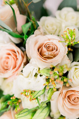 A beautiful arrangement of pink and white flowers and pops of greenery. A wedding band and engagement ring is inside one of the pink roses