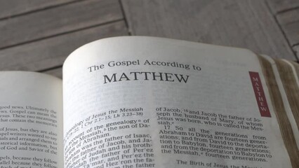 Close up and panning view on the book of Matthew of the bible. - Powered by Adobe