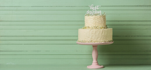 Stand with beautiful wedding cake on green wooden background with space for text