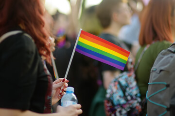Activist woman holding rainbow flag and banner on the march on the city street during the Lgbt...