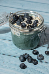 Glass jar with natural organic homemade yogurt and blueberries spirulina chlorella superfood super powder blue algae sea weed. Immunity-boosting ingredients. Concept of healthy eating breakfast of