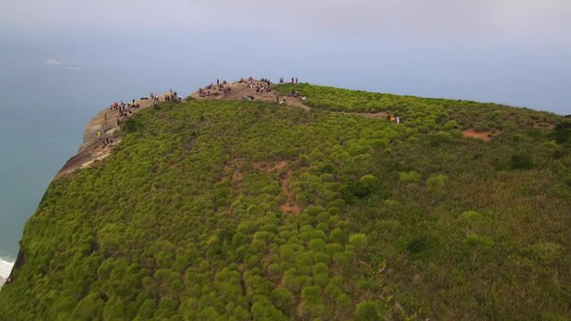 Filmagem a&eacute;rea com drone de pessoas no topo de uma montanha chamada Pedra da G&aacute;vea, no Rio de Janeiro.