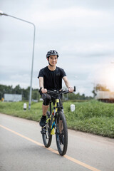 Shot of happy asian guy enjoying biking in the summer park. Sport, leisure and healthy lifestyle concept