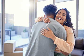 Happy couple, hug and real estate with key for new home, moving in or mortgage loan together...