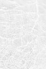 White water with ripples on the surface. Defocus blurred transparent white colored clear calm water surface texture with splashes and bubbles. Water waves with shining pattern texture background.
