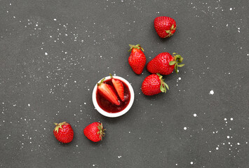 Bowl with sweet strawberry jam and fresh berries on grunge background