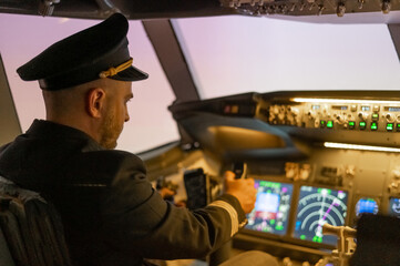 Caucasian bearded man controls the plane and looks at the beautiful sunset sky. 