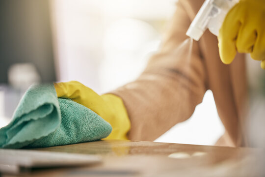 Person, hands and detergent on table with cloth for hygiene, bacteria or germ removal at home. Closeup of cleaner, housekeeper or maid wiping furniture in domestic service or disinfection on surface