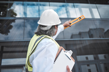 Engineering, checklist and man with tools at construction site inspection, urban development or city project management. Manager or person from behind for outdoor architecture and clipboard survey