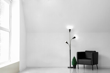Glowing lamp with armchair and houseplant in light room