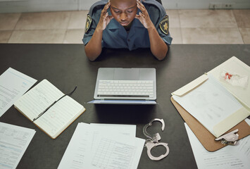 Police, woman and working with stress at desk with documents, paperwork or frustrated with headache...