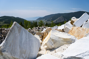 marble quarry. Large white marble blocks in an old abandoned quarry. Beautiful marble texture. Smooth cuts at the stones. Large boulder of white marble.  Selective focus.