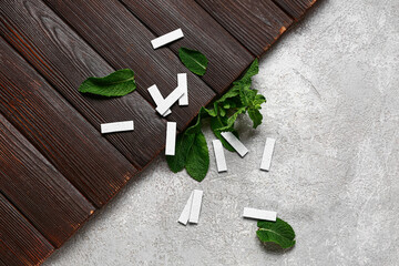 Fresh chewing gums with mint on wooden and grunge background