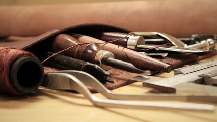 Pieces of leather and hand-tools on wooden table