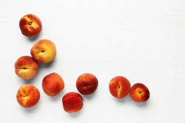 Many sweet peaches on white wooden background