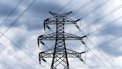 High voltage line transmission tower cloudy day with dark clouds