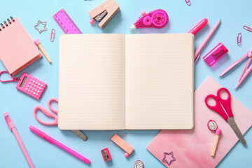 Composition with blank notebook and different school stationery on blue background