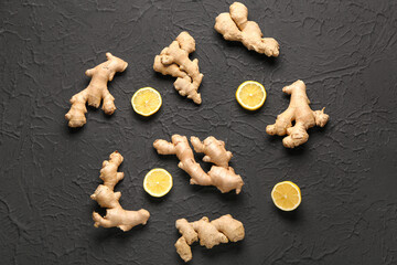 Fresh ginger roots with slices of lemon on black background