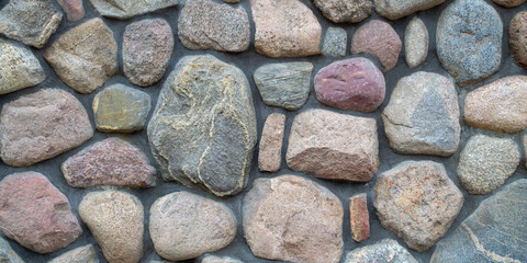 Banner. Natural big textured stone. Fragment of a colored stonewall. background.