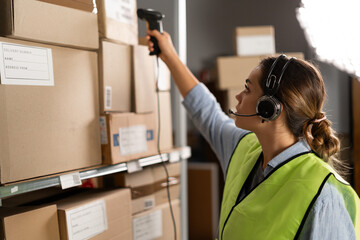 warehouse worker scans a barcode on a box in a large warehouse. brazilian woman worker scans...