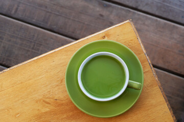 a cup of hot milk green tea on the table, top view. adding milk to green tea can result in a smoother and creamier texture with a milder flavor profile compared to plain green tea