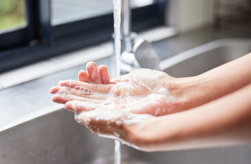 Water, tap and person washing hands with soap for skincare, healthy dermatology and bacteria safety at home. Closeup, basin and cleaning hand with foam for hygiene routine, wellness and protection