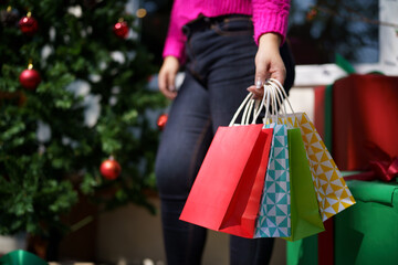Happy asian girl hold shopping bags Xmas present. cheerful woman with Christmas New Year Winter sale
