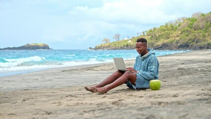 Male freelancer work near ocean. African american guy use macbook laptop. Black person rest open air. Afro man typing computer. Sea beach view. Marine shore. Focused outdoor job. Happy digital nomad.