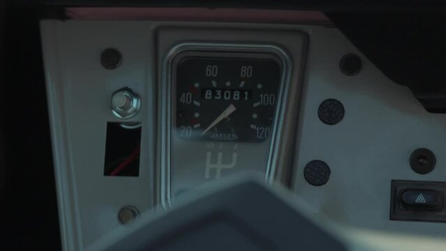 Hand-held shot of a vintage Deux Chevaux cars odometer with someone driving