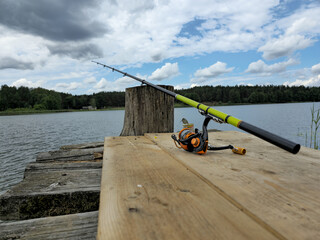 A fishing rod on a wooden bridge by the lake. Lithuania