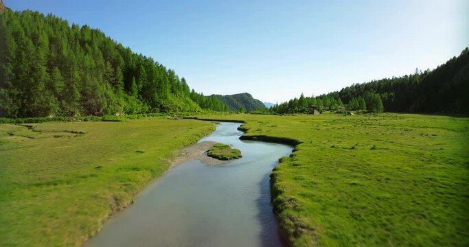 Flying over Duino river in Val Masino with forest in background and sky for copy space