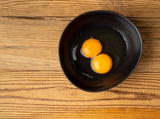 Two Broken Eggs in Bowl Isolated, Raw Yolk and White, Fresh Broken Organic Chicken Eggs