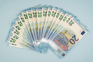 many 20 euro bills on a blue background