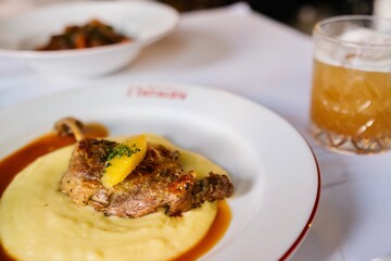 A plate of canard a l’orange (orange duck) — confit duck leg with potato purée and orange sauce — at a French bistro in Circular Quay, Sydney. New South Wales, Australia