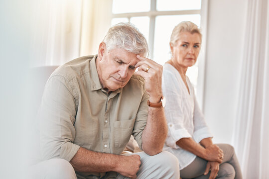 Senior couple, divorce and headache in conflict, fight or argument on the living room sofa at home. Elderly woman and frustrated man in depression, cheating affair or toxic relationship in the house