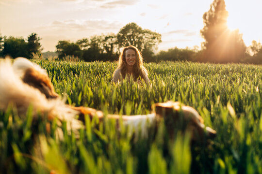 portrait of a smiley lady out in the meadow with her dog