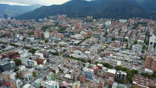 Cinematic Establishing Shot Of Large Urban City Area During Daylight With Mountain Background. 4K Aerial Drone View.