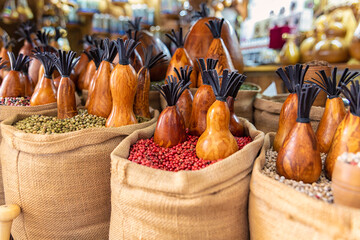 Bags full of various multicolored spices and traditional wooden saltshaker as souvenir on a market...