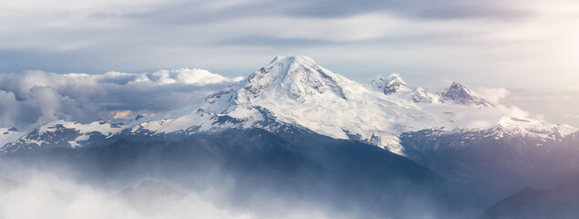Mt Baker covered in snow and clouds. Aerial landscape nature background.