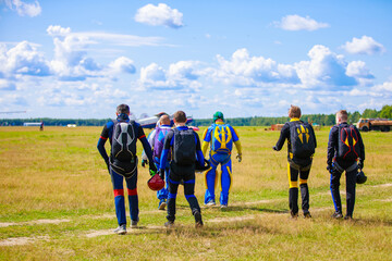 Skydivers-athletes are on the airfield, preparing to jump.