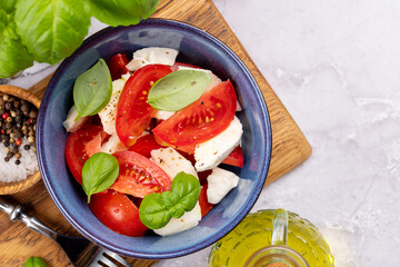 Caprese salad with ripe tomatoes, mozzarella cheese and garden basil