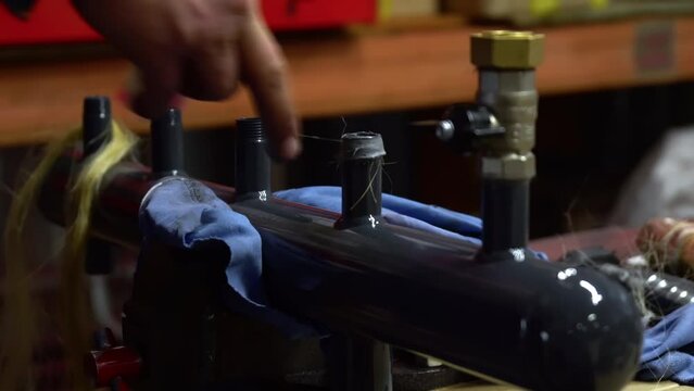 Man's Hand Greasing Thread And Adjusting Sealing Cord To A Pipe Construction. Pipes Manufacturing Process. Industrial Plant For Pipes Production. Manual Labor. Working Process. Close Up.