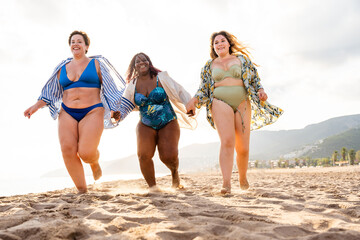 Group of plus size women with swimwear at the beach - Multiethnic curvy adult female having fun and...