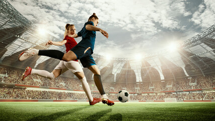Dynamic image of two women, athletes, football players in motion during match running with ball on 3d arena. Blurred audience. Concept of professional sport, competition, dynamics, game, ad