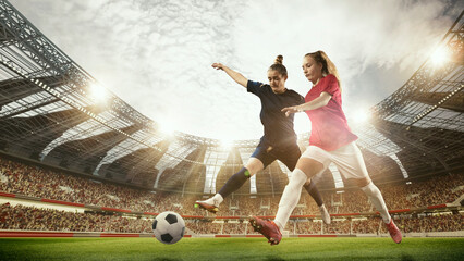 Two women, professional football, soccer players in motion during match, game at 3d open air stadium arena with blurred fans. Concept of professional sport, competition, dynamics, game, ad