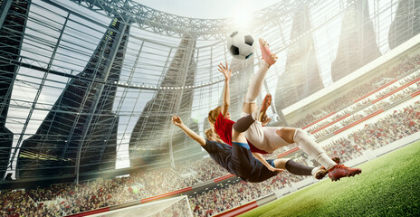 Tense game moment. Dynamic image of two women, football players in motion, hitting ball in jump during match on 3D open air stadium. Concept of professional sport, competition, dynamics, game, ad