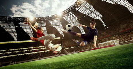 Professional female football players in motion during tense game, hitting ball, playing on 3D open...