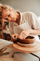 Fototapeta na wymiar I love working with clay. Cropped shot of a woman shaping a clay pot in her workshop.