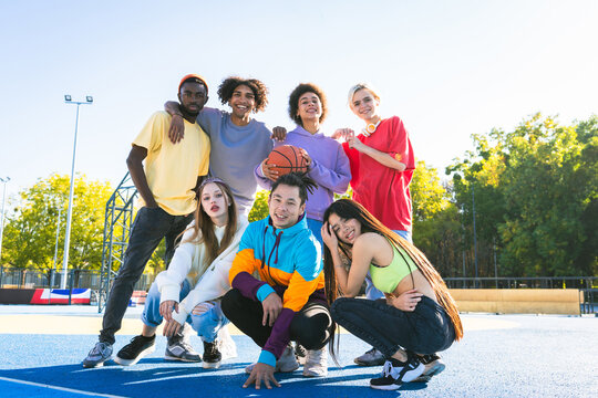 Multiracial group of young friends bonding outdoors - Multiethnic happy and playful people with colorful stylish clothes portrait, concepts of diversity and youth lifestyle